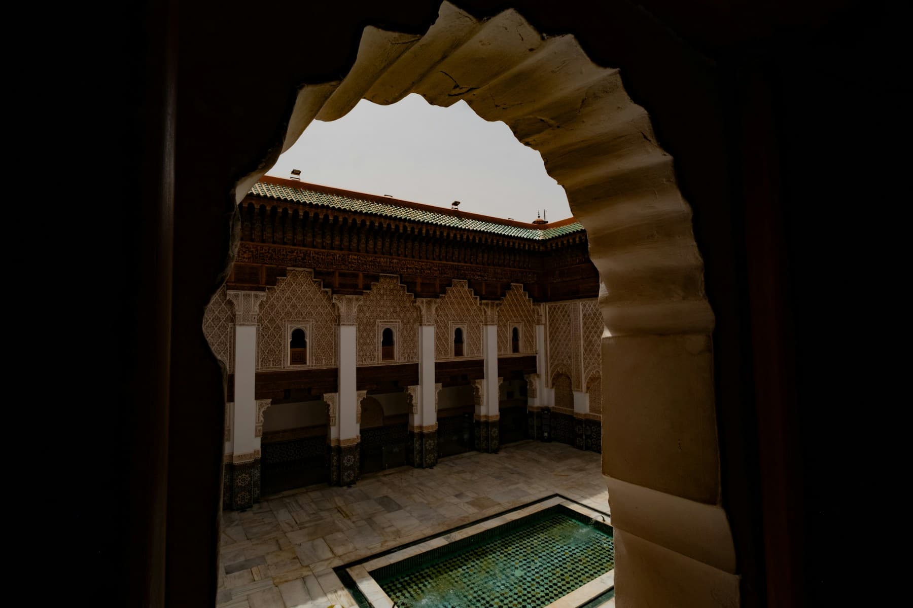 Marrakech riad courtyard with arches and pool, a premium Airbnb concierge signal.