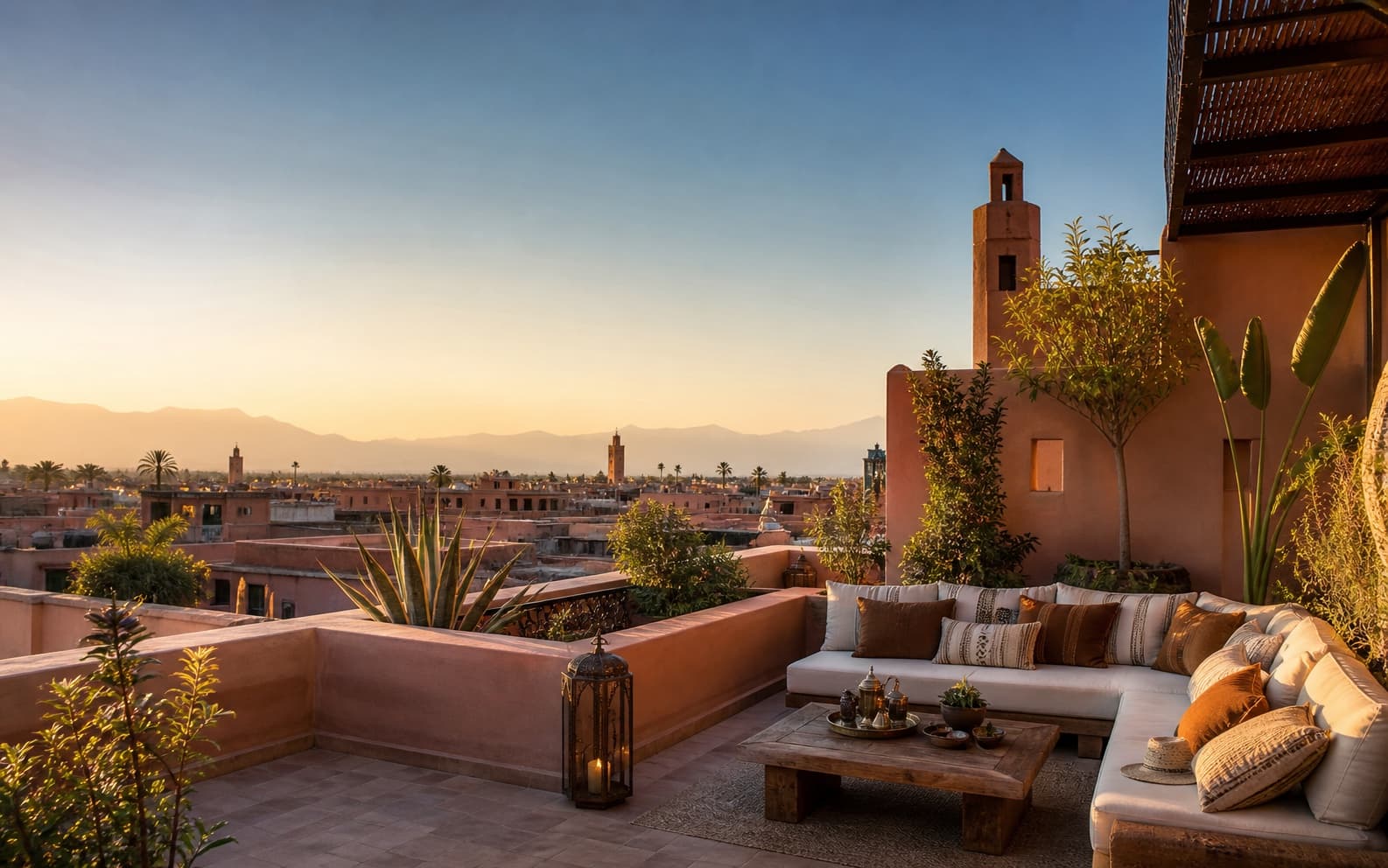 Terrasse de riad haut de gamme à Marrakech avec vue sur les toits et les montagnes de l'Atlas.